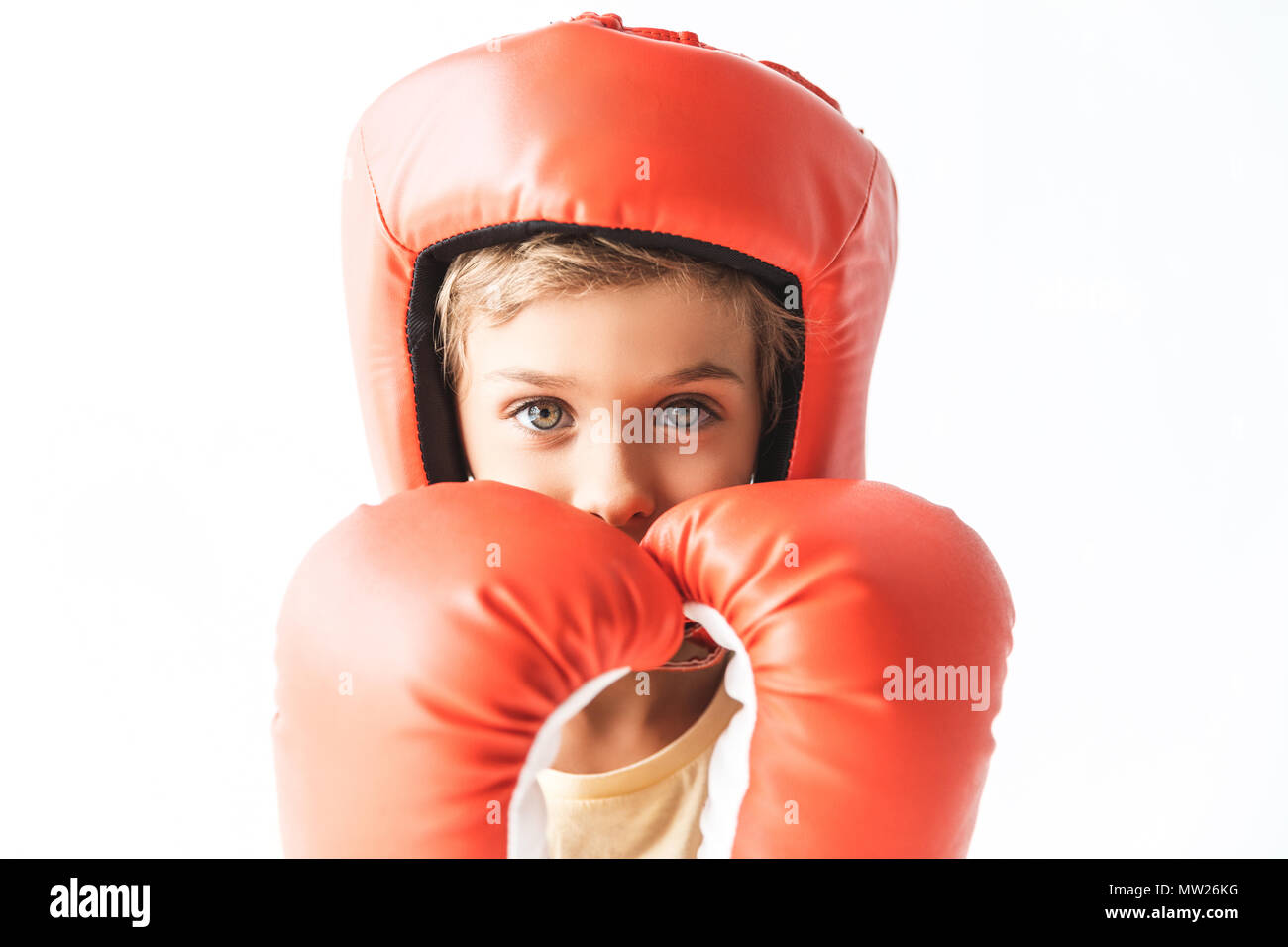 Petit garçon en rouge gants de boxe et casque looking at camera isolated on white Banque D'Images