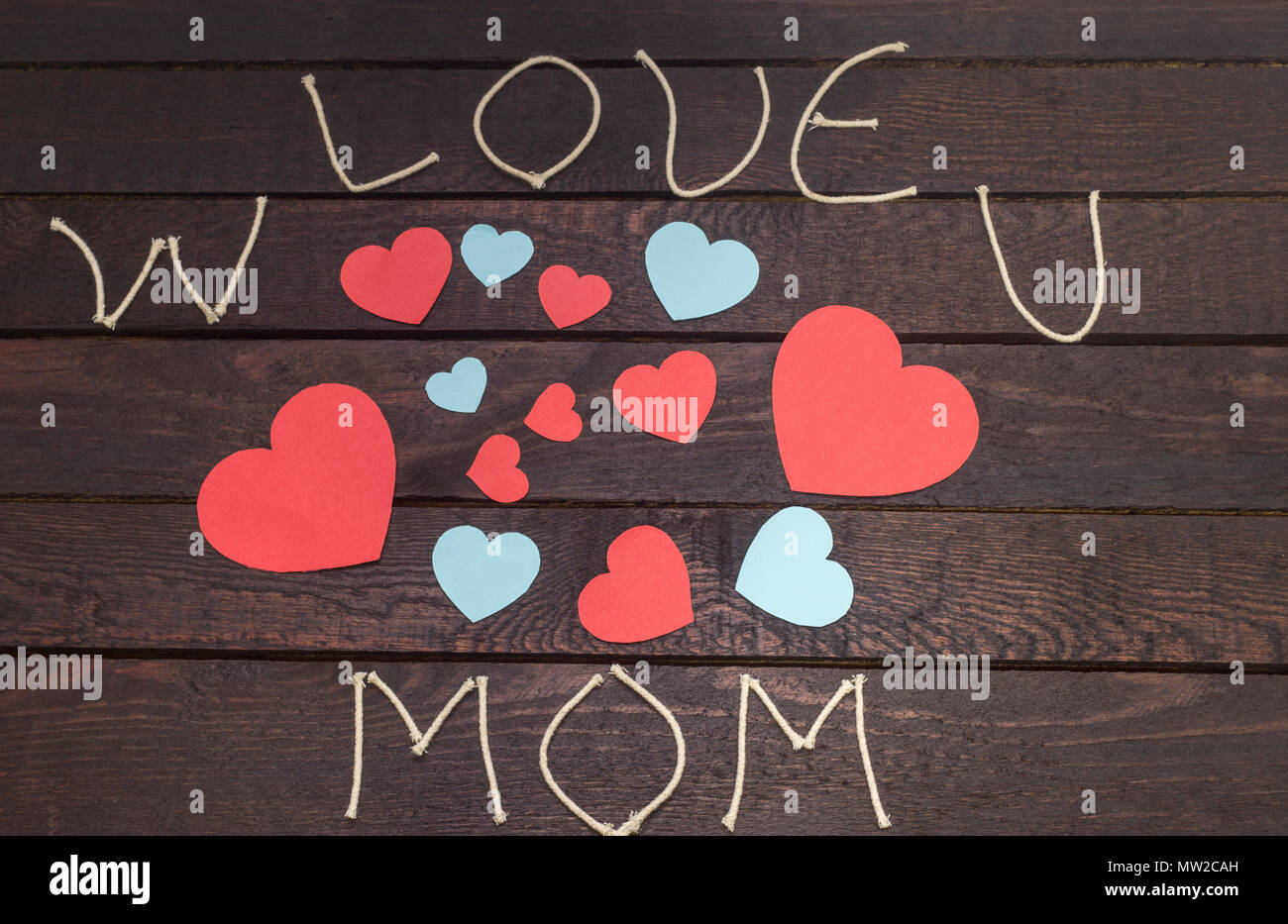 Formant le mot : W love u mom sur fond de bois. Banque D'Images