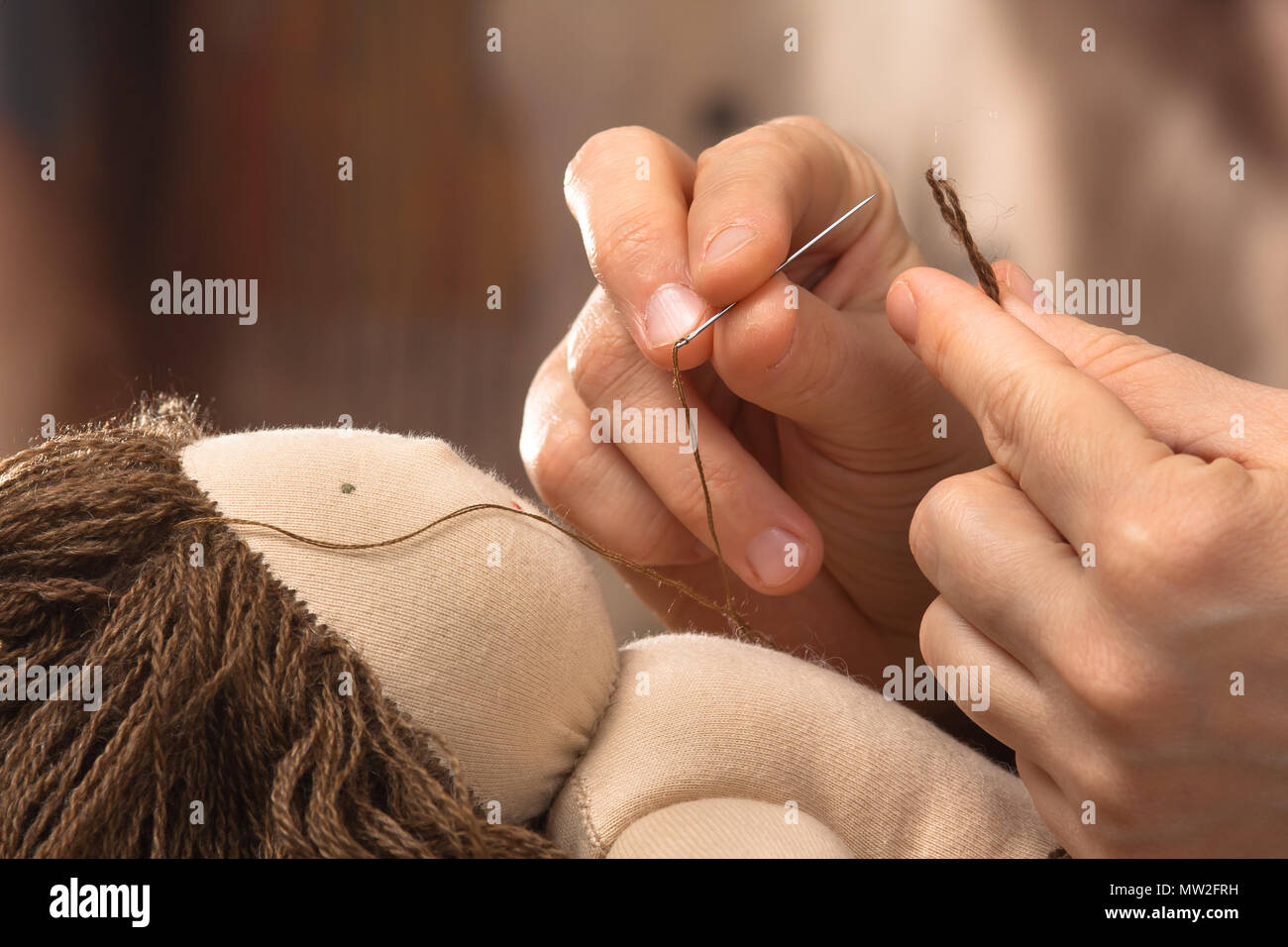 Mains de femme au cheveux couture poupée Waldorf, gros plan Banque D'Images