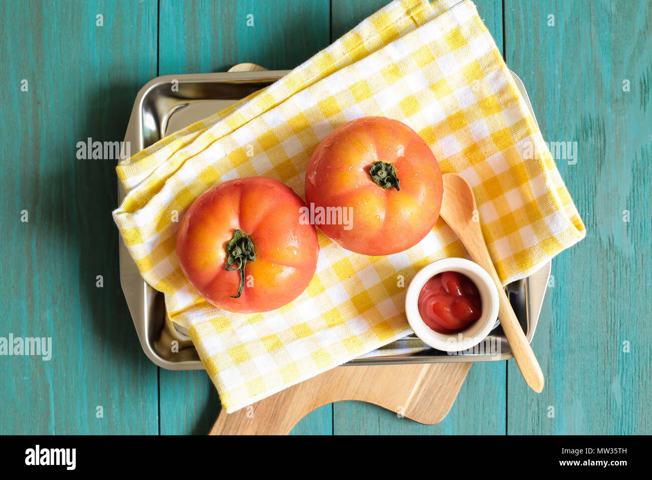 Les tomates fraîches et le ketchup sur style vintage table en bois peint en vert Banque D'Images
