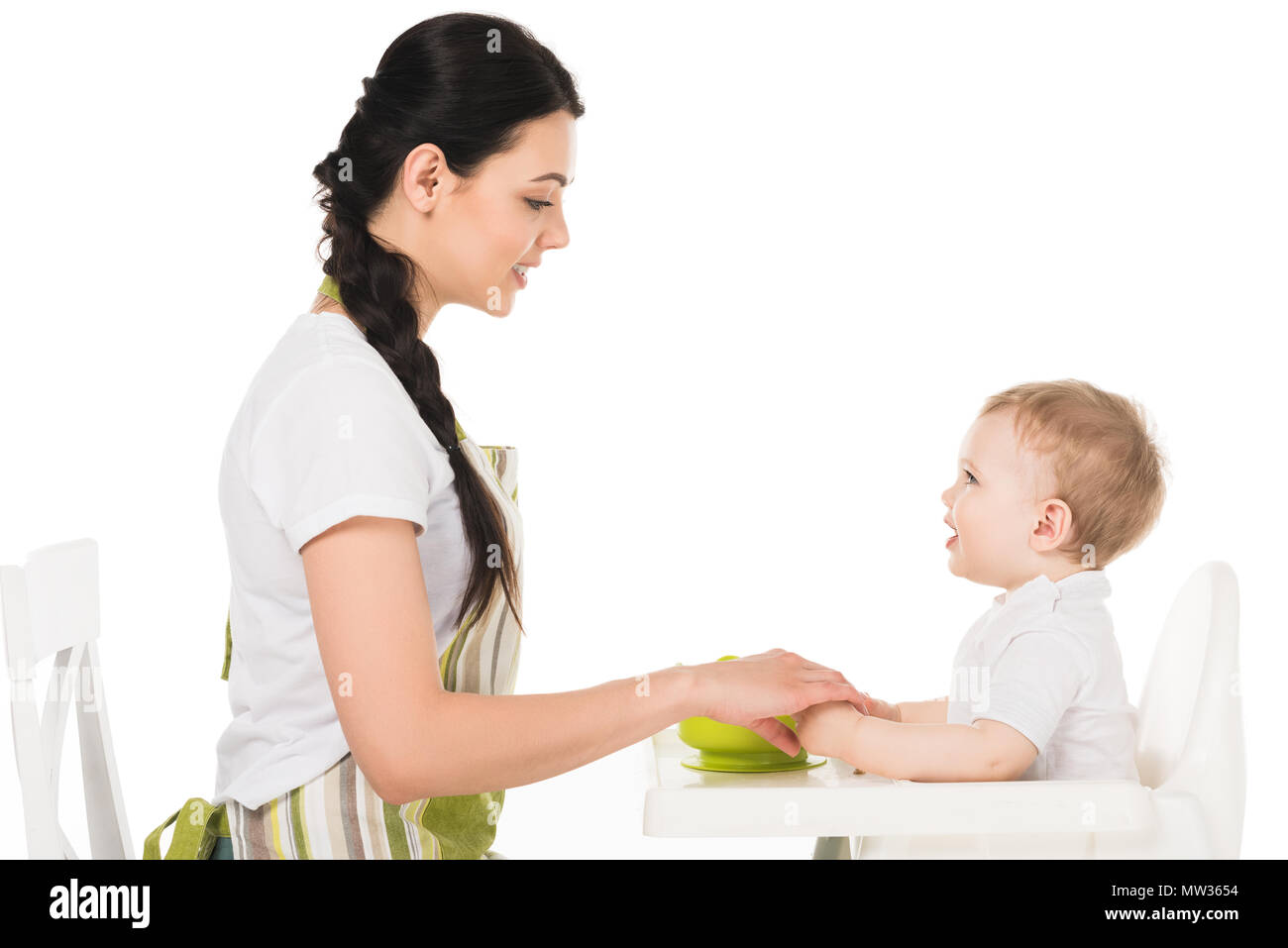 Vue de côté mère tenant la main de bébé dans une chaise haute isolé sur fond blanc Banque D'Images