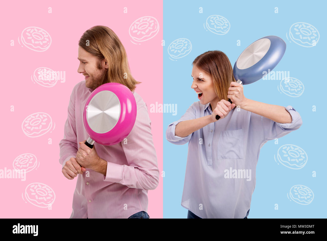 Femme menace son mari furieux tout en portant une grande poêle Banque D'Images