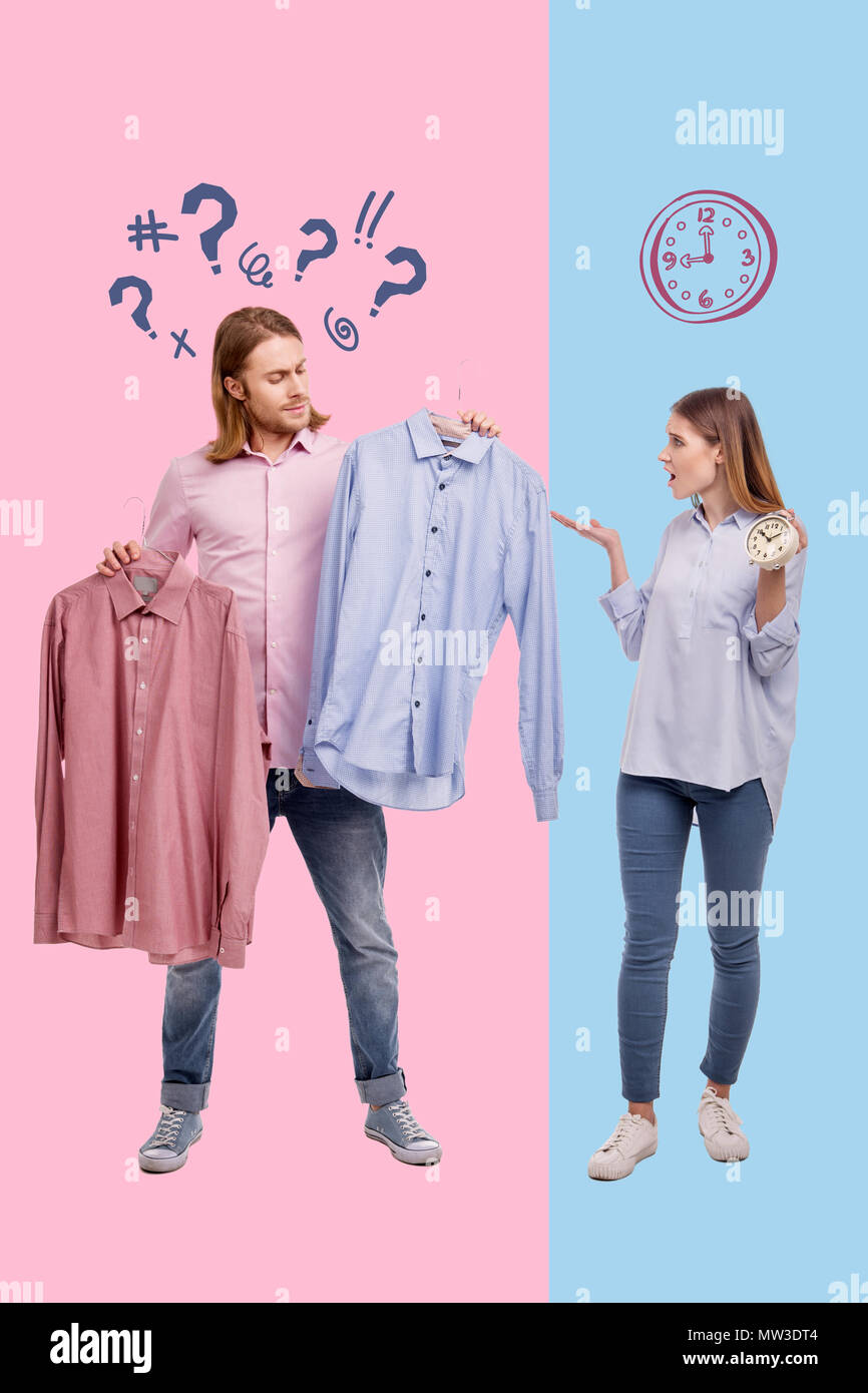Femme émotionnelle sentiment irrité alors que son mari choisissant shirts calme Banque D'Images