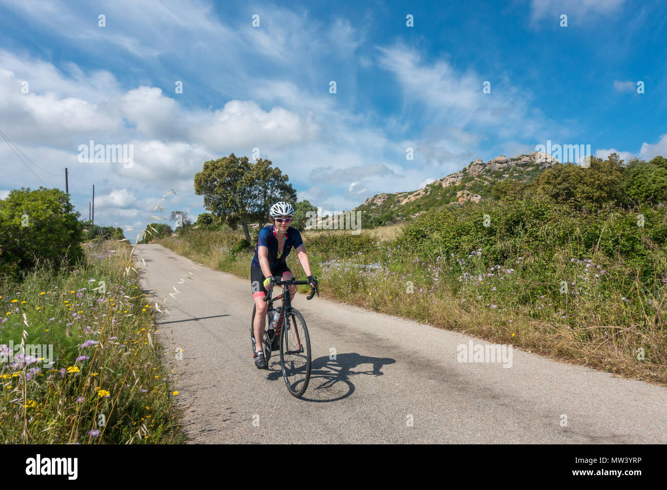 Cycliste féminine rouler à vélo à travers la belle campagne de la Sardaigne. Banque D'Images