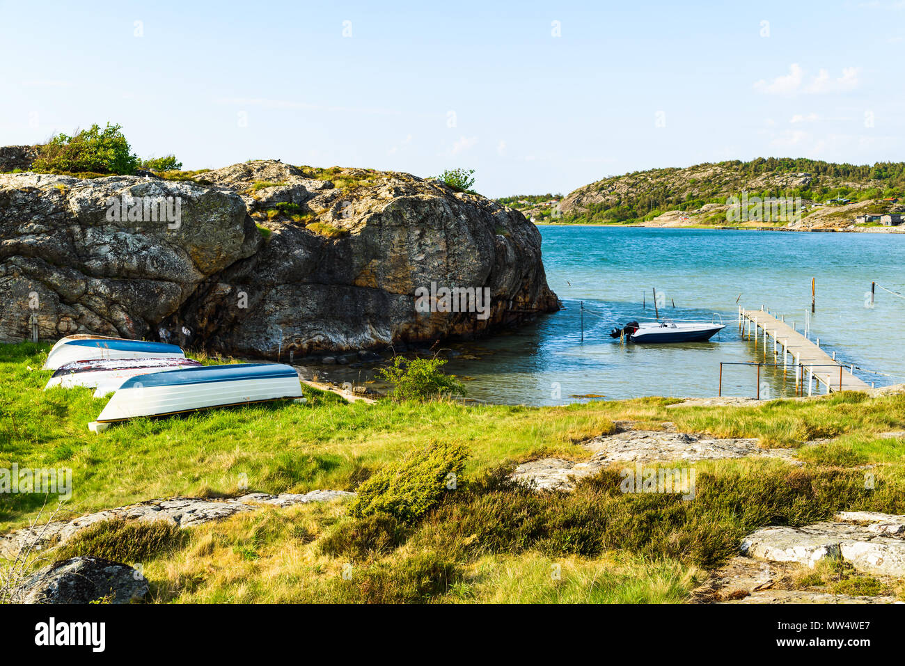 Falaise côtière paysage sur une journée ensoleillée, avec des bateaux à terre et amarré par la jetée. Arod, à l'extérieur de Kungalv, Suède. Banque D'Images