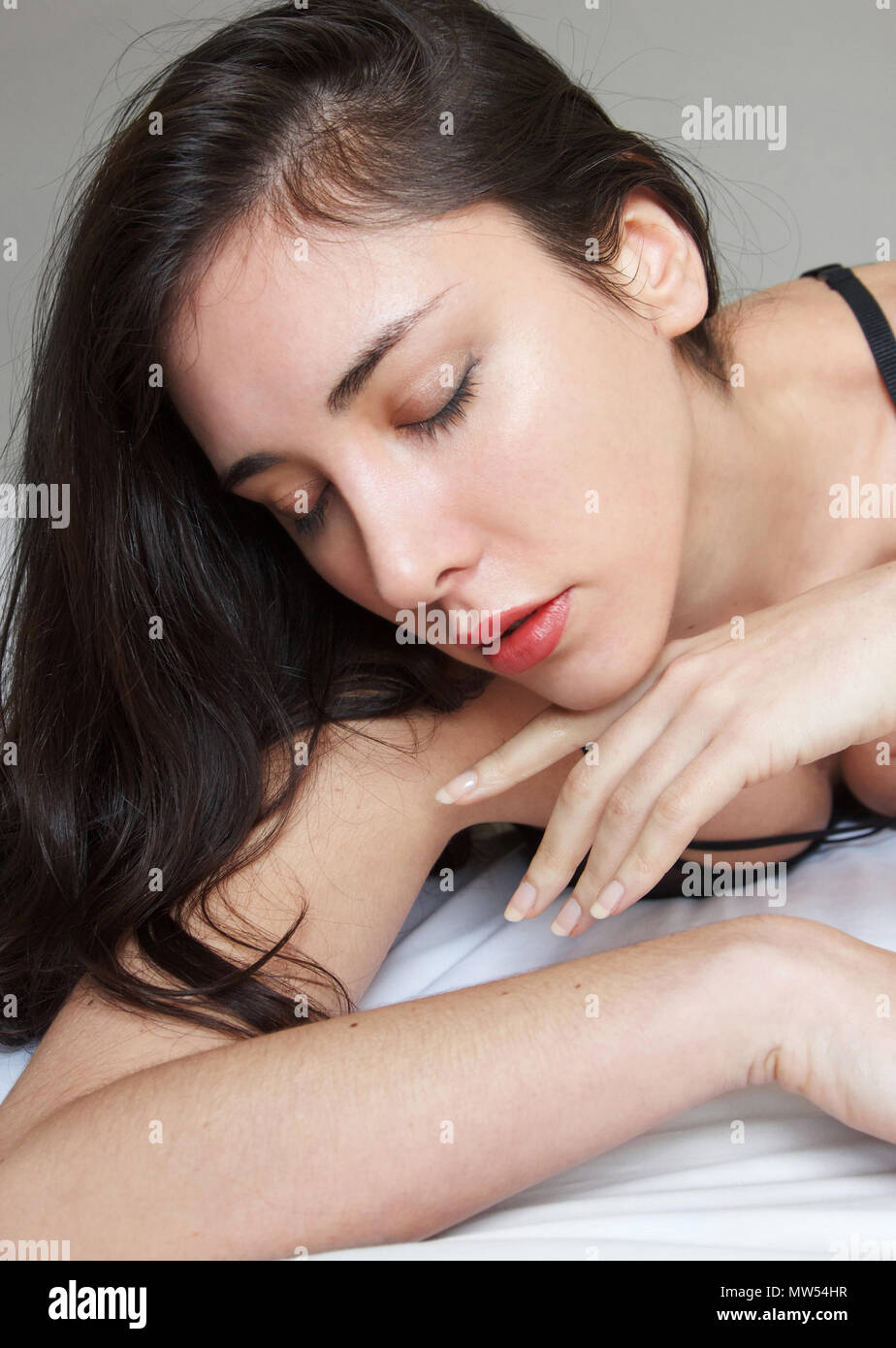 Jeune femme italienne avec les cheveux bruns et des lèvres rouges et plein les yeux baissés Banque D'Images