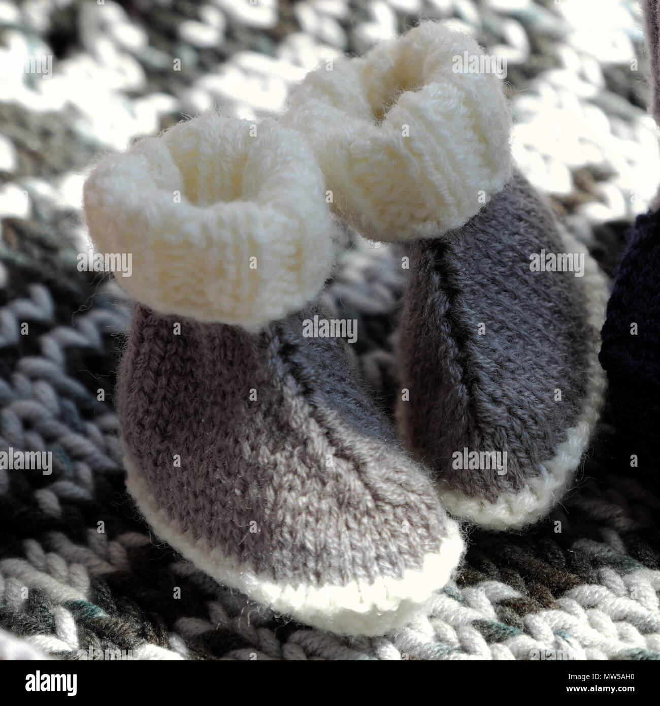 Chaussons pour bébé tricotés à partir de fils nouveau-né pour couverture de laine sur les produits faits main, mignonne pour chaussures Banque D'Images