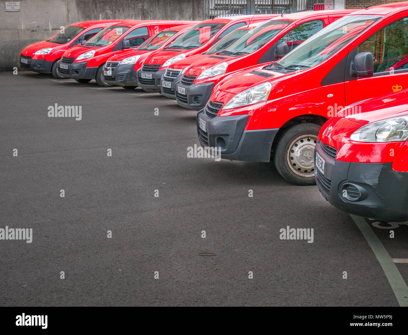 Un groupe de red Royal Mail cars dans un parking au centre-ville de Kettering, Angleterre. Banque D'Images