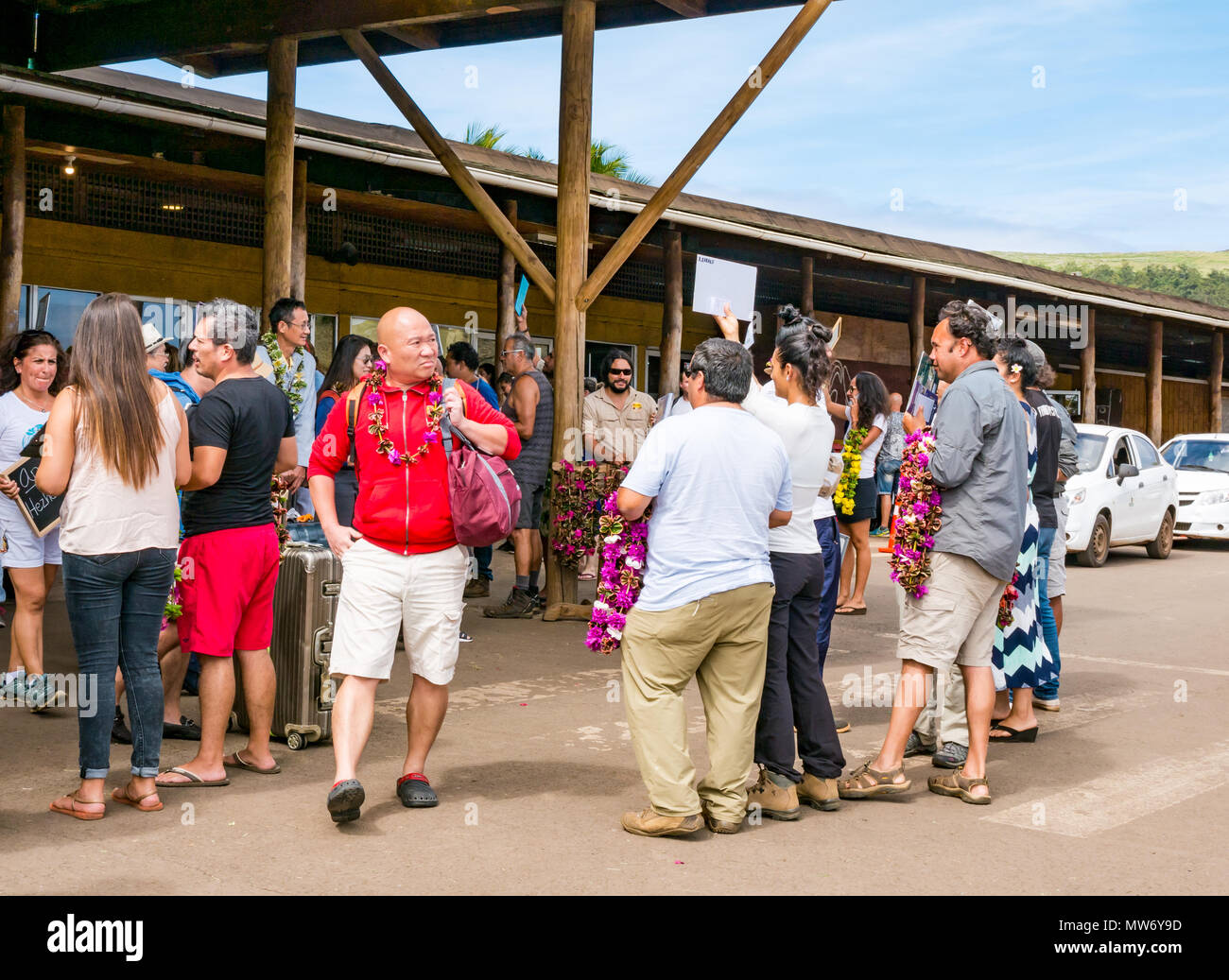 Terminal des arrivées de l'aéroport international Mataveri, île de Pâques, Chili, de touristes accueillis par les tour-opérateurs en les accueillant avec lei guirlandes Banque D'Images