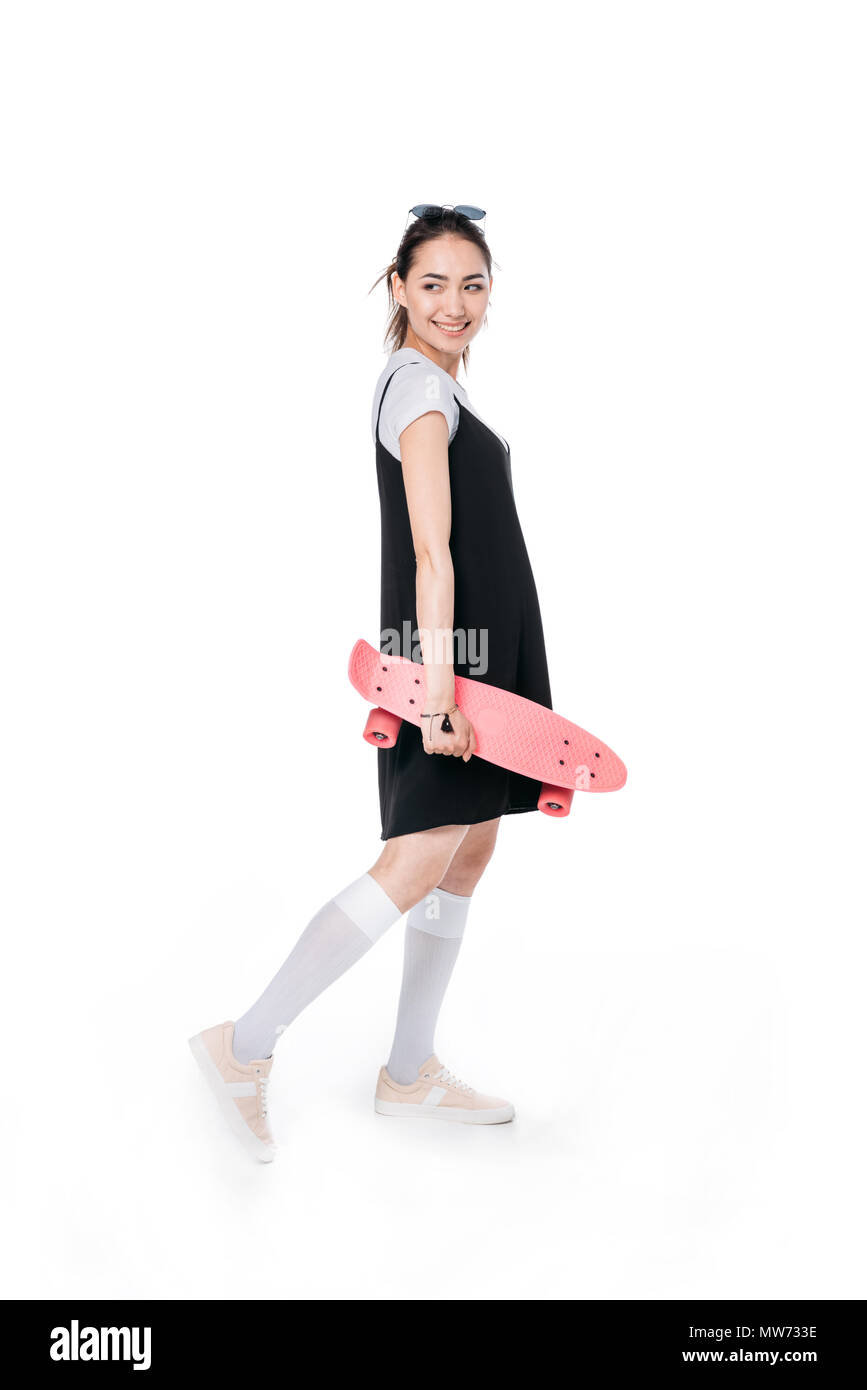 Young Asian woman posing with skateboard isolated on white Banque D'Images