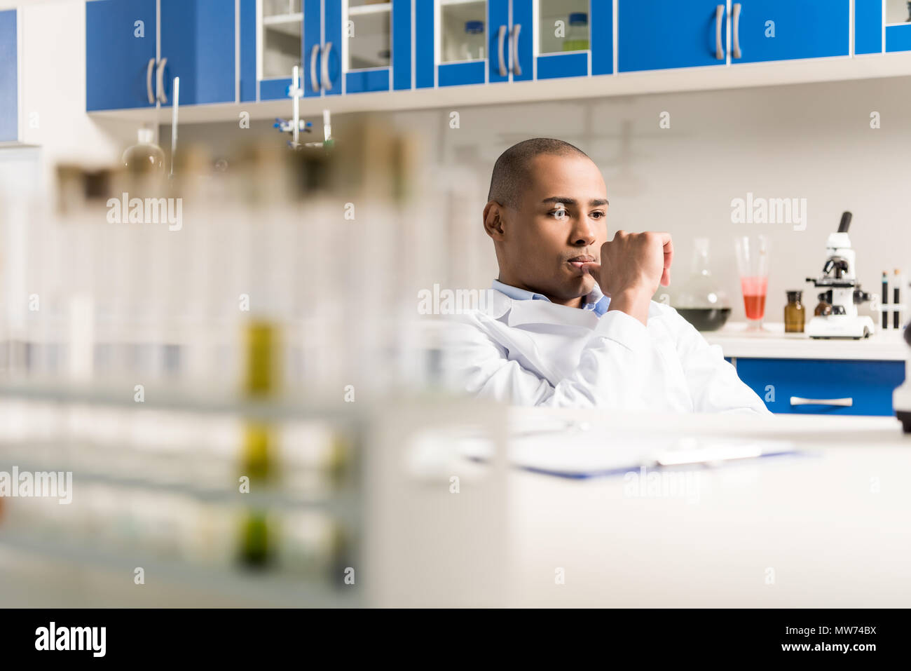 Libre pendant le travail au laboratoire de biologie moderne sitting with hand on chin Banque D'Images