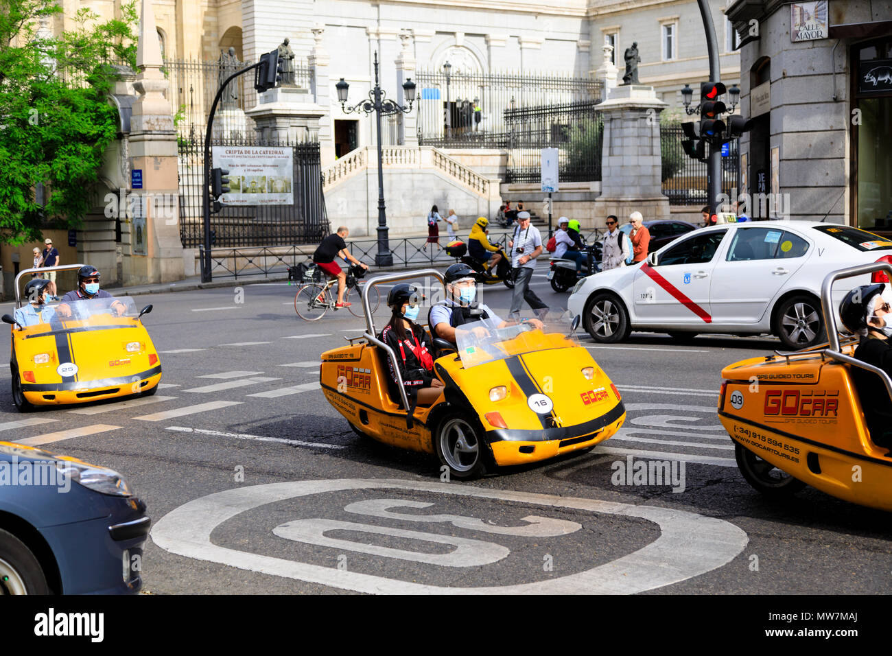 3 roues Gocars transportant des touristes chinois portant des masques smog d'une visite guidée de Madrid, Espagne. Mai 2018 Banque D'Images