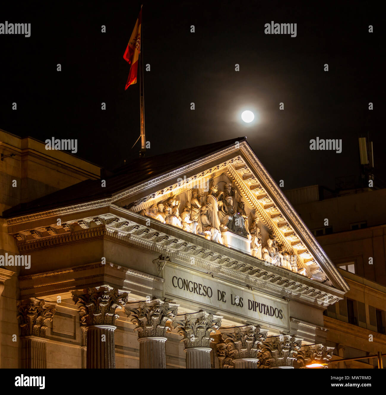 L'architecture espagnole de lumières avec drapeau sur le toit avec la pleine lune sur le contexte et les personnes non focalisé Banque D'Images