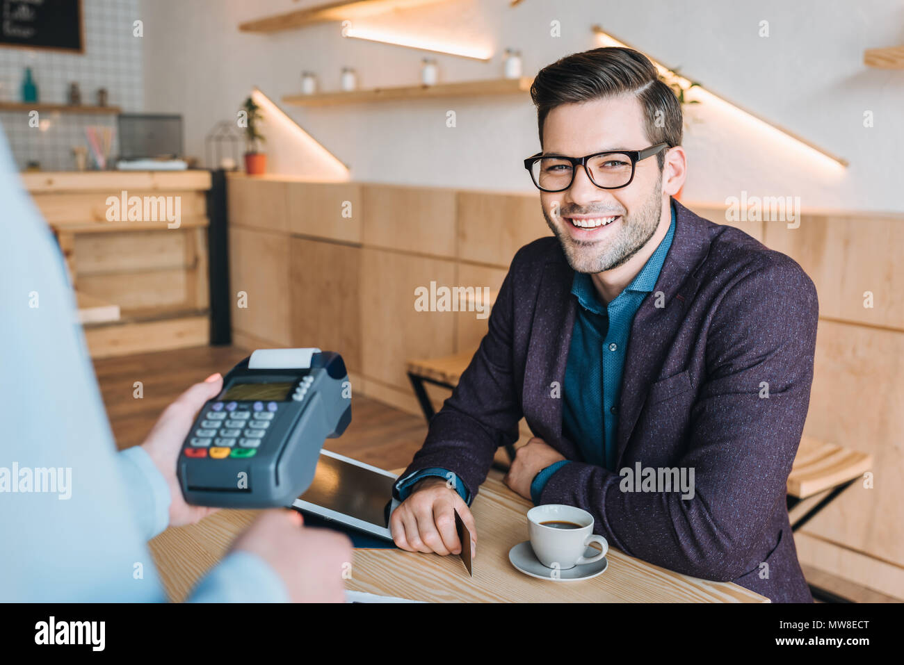 Portrait of smiling businessman with credit card payer pour commander in coffee shop Banque D'Images