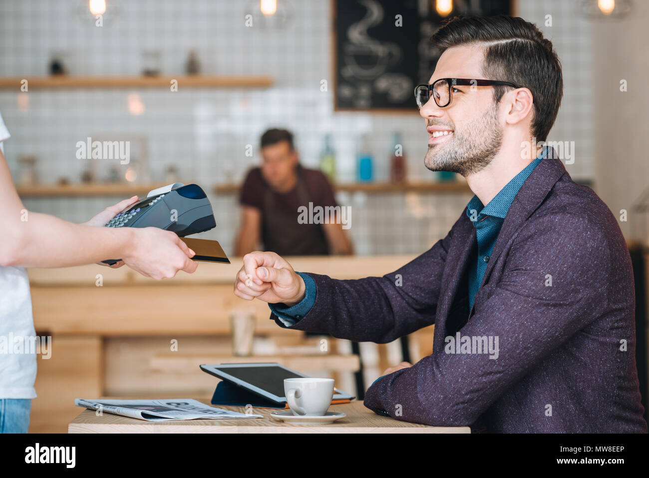 Side view of businessman tasse de café pour payer avec carte de crédit au cafe Banque D'Images