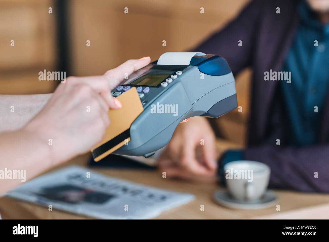 Cropped shot serveuse de traitement des paiements par carte de crédit et carte reader in cafe Banque D'Images