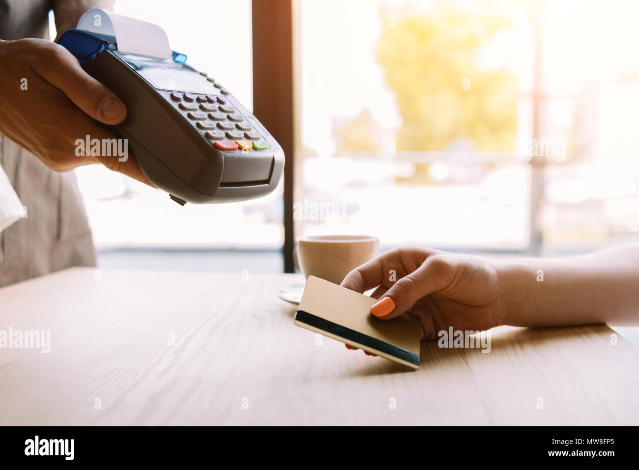 Vue partielle de femme de payer par carte de crédit en main in cafe Banque D'Images