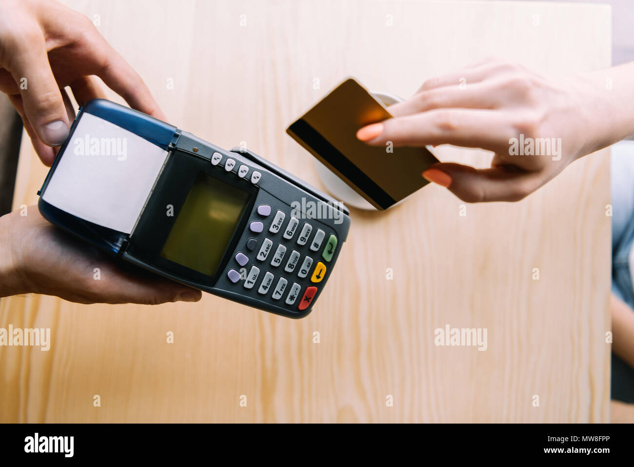 Vue partielle de femme de payer par carte de crédit en main in cafe Banque D'Images