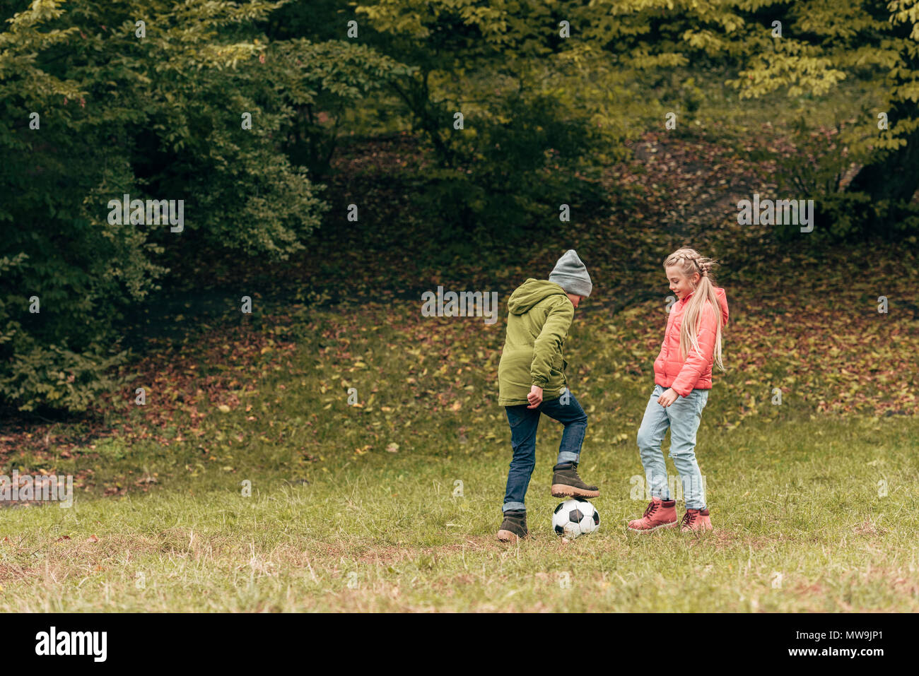 Cute little kids playing soccer in autumn park Banque D'Images