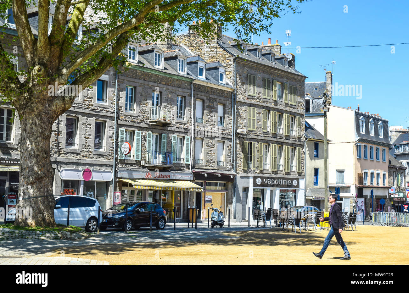 Homme enjamber la sable en terre tassée dans une place de la ville qui est utilisé comme un terrain de pétanque à Saint Brieuc, Bretagne, France. Banque D'Images