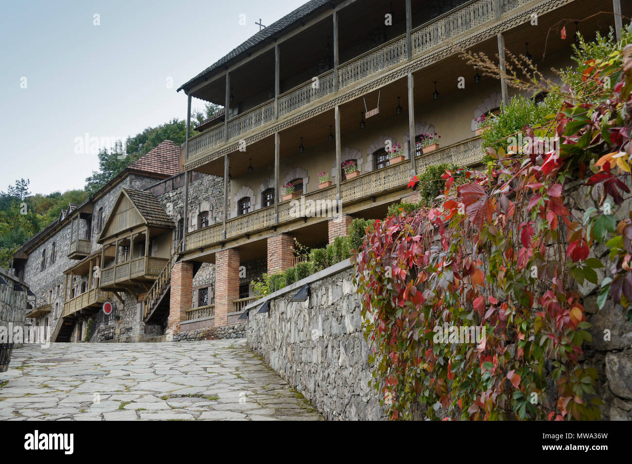 Les bâtiments traditionnels en pierre et en bois, maintenant utilisé comme magasins, restaurants, et un hôtel, le long d'une rue de l'ardoise dans le centre historique de Dilijan, Dilijan, Arménie Banque D'Images