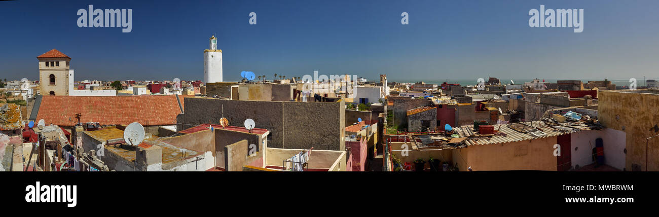 Panorama photographique de la toiture de la ville d'El Jadida, des murs lumineux des bâtiments, windows, corde à linge lavé, vieux débris, contre le bleu Banque D'Images