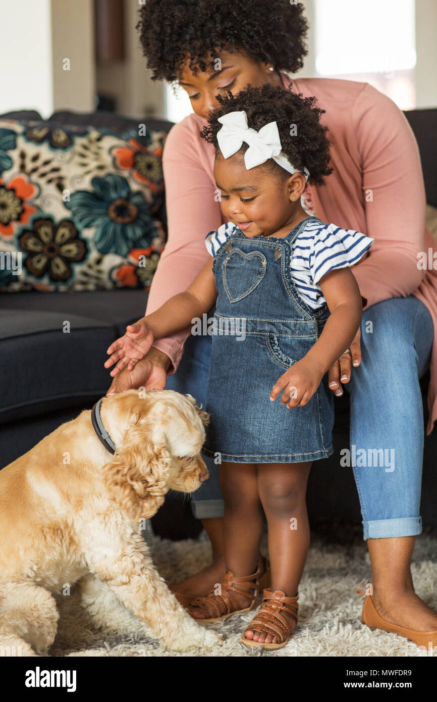 Petite fille et sa maman jouer avec leur chien. Banque D'Images