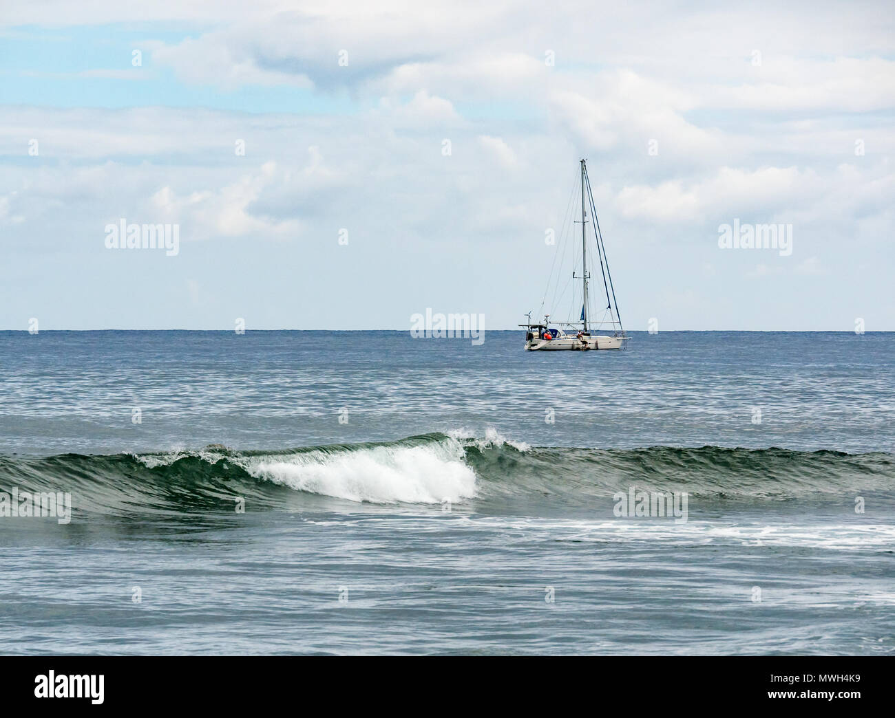 Bateau à voile avec Pacific Ccean déferlante en premier plan, l'île de Pâques, Rapa Nui, Chili Banque D'Images