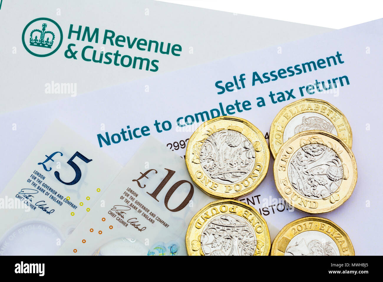 HM Revenue & Customs HMRC Avis d'auto-évaluation à remplir une déclaration d'impôt au Royaume-Uni avec de nouvelles pièces livre et notes d'argent pour payer les impôts. Angleterre Royaume-uni Grande-Bretagne Banque D'Images