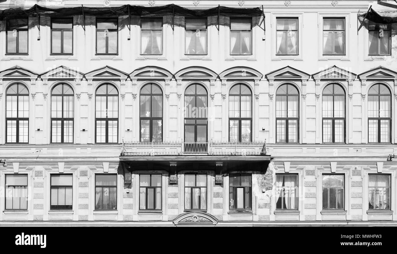 La tonalité de l'image. Façade d'un immeuble ancien avec de grandes fenêtres et murs délabrés. Les maisons d'arrière-plan Banque D'Images