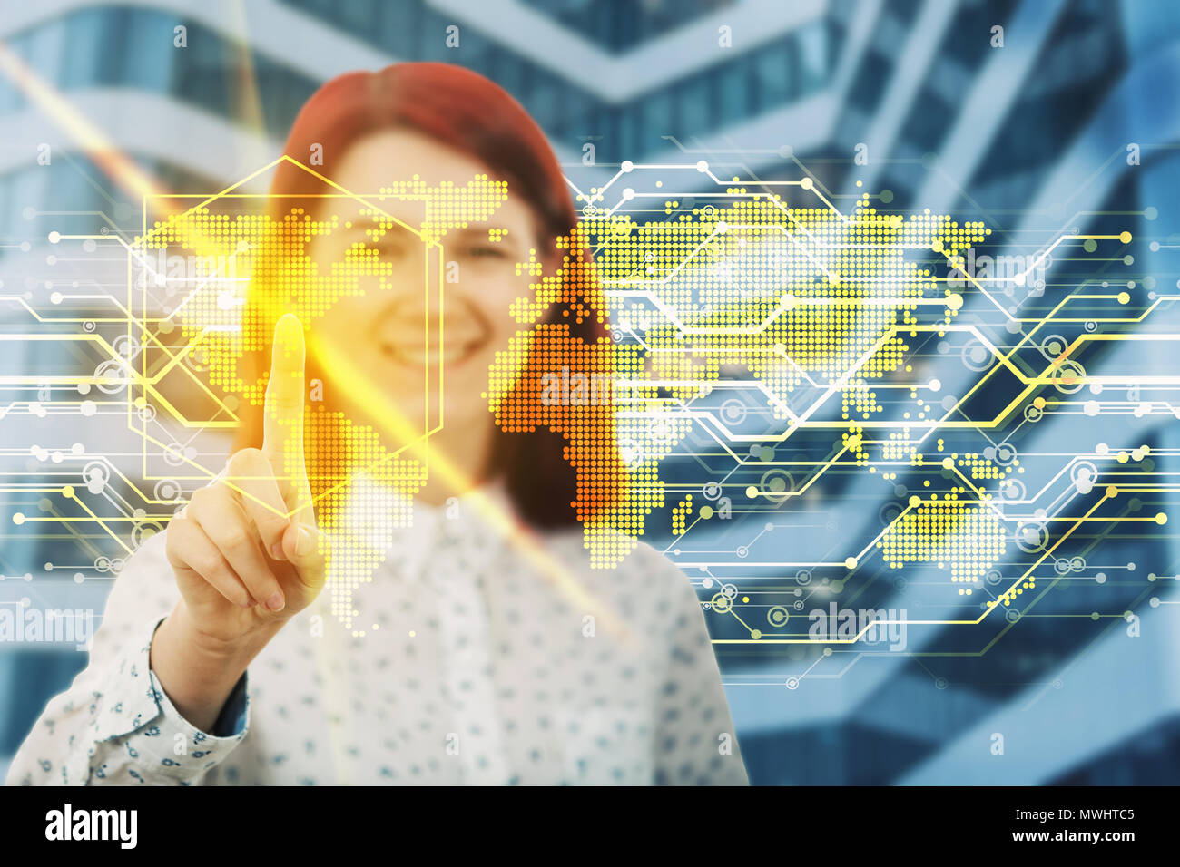 Smiling woman touching digital interface de l'écran avec son doigt. Choisissez un endroit sur la carte du monde d'hologramme. Le développement de technologie d'entreprise. Vir Banque D'Images