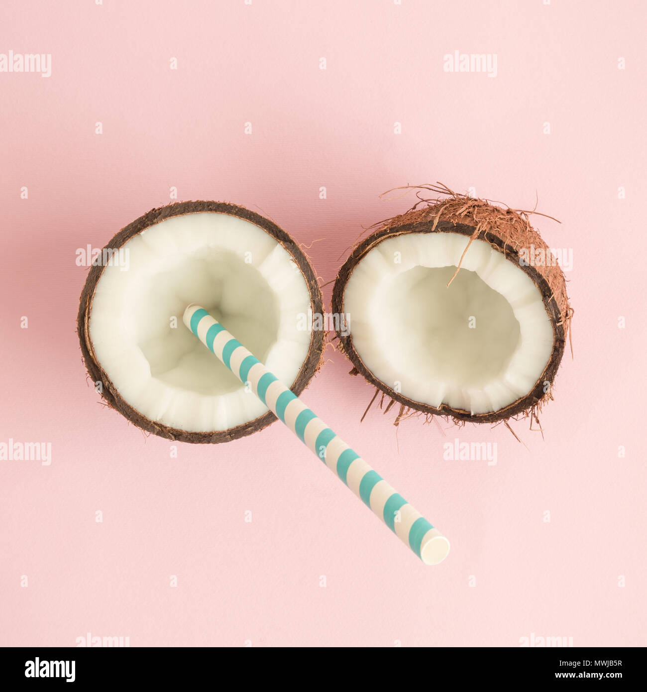 Boisson aux fruits de noix de coco sur fond rose pastel contre un minimum de concept créatif. Banque D'Images