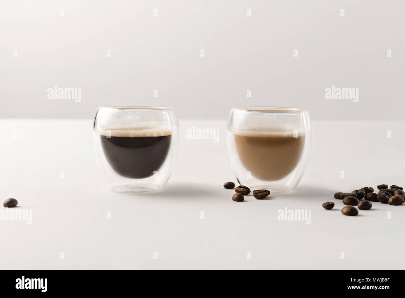 Deux tasses de café sur fond blanc avec grains de café Banque D'Images