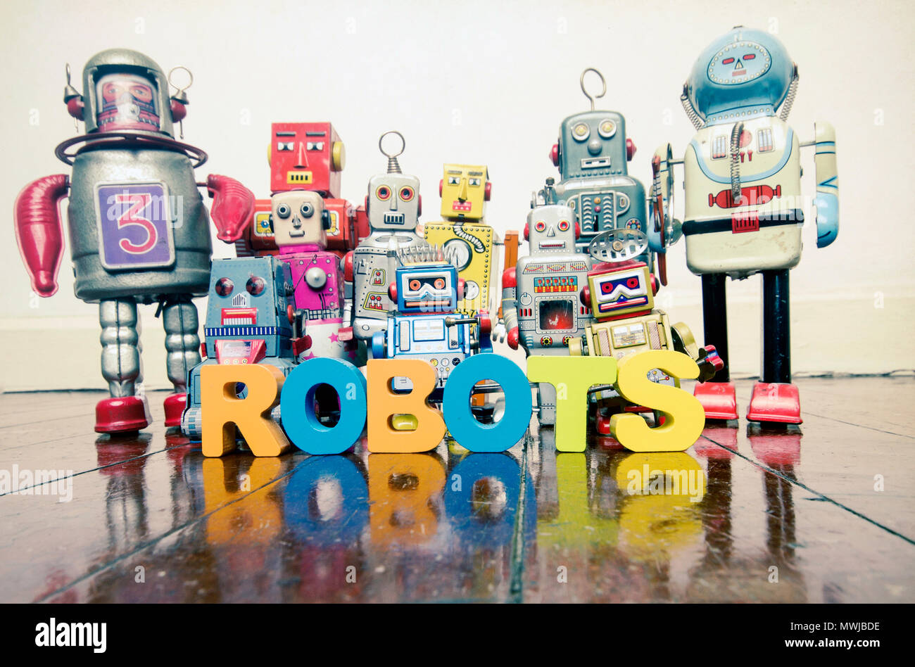 Le mot des robots avec des lettres en bois et de jouets rétro robots sur un  vieux plancher en bois avec réflexion Photo Stock - Alamy
