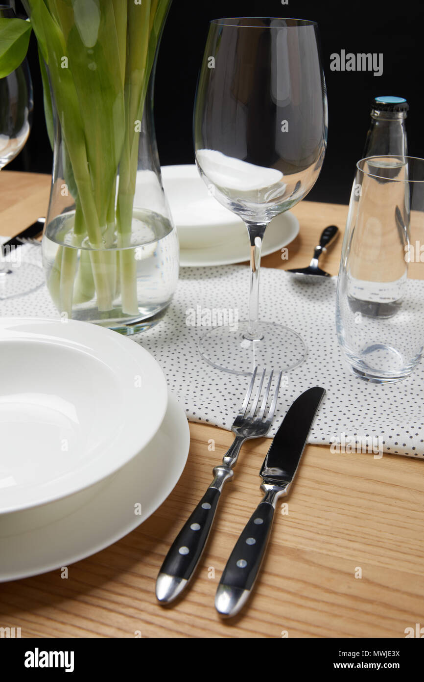 De la vaisselle avec des verres sur la table à côté de bouquet dans un vase Banque D'Images