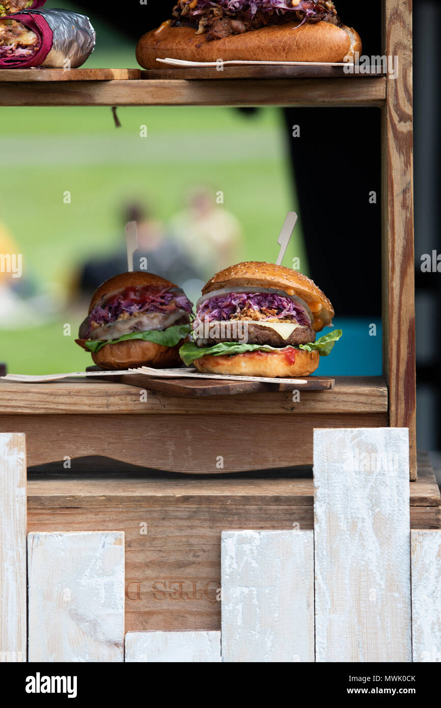 Burgers à la main sur un stand à un festival gastronomique. Oxfordshire, Angleterre Banque D'Images