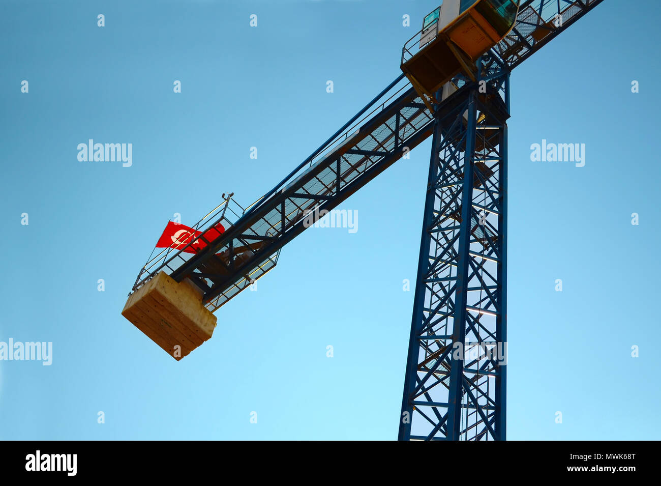 Grue de construction avec le drapeau turc sur le dessus sur le ciel sans nuages, vue de bas en haut. Banque D'Images