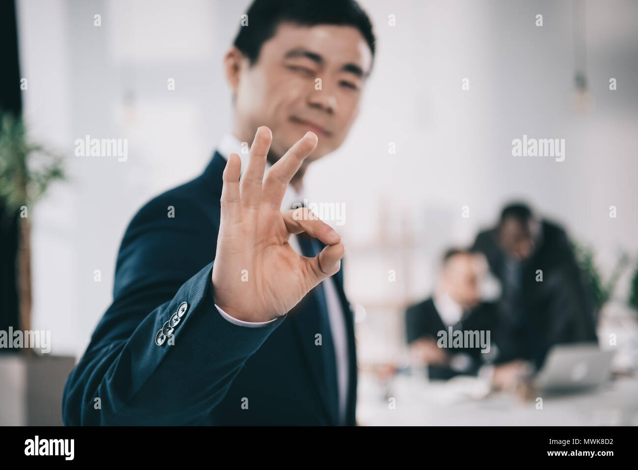 Bel asiatique réussie businessman showing ok sign Banque D'Images