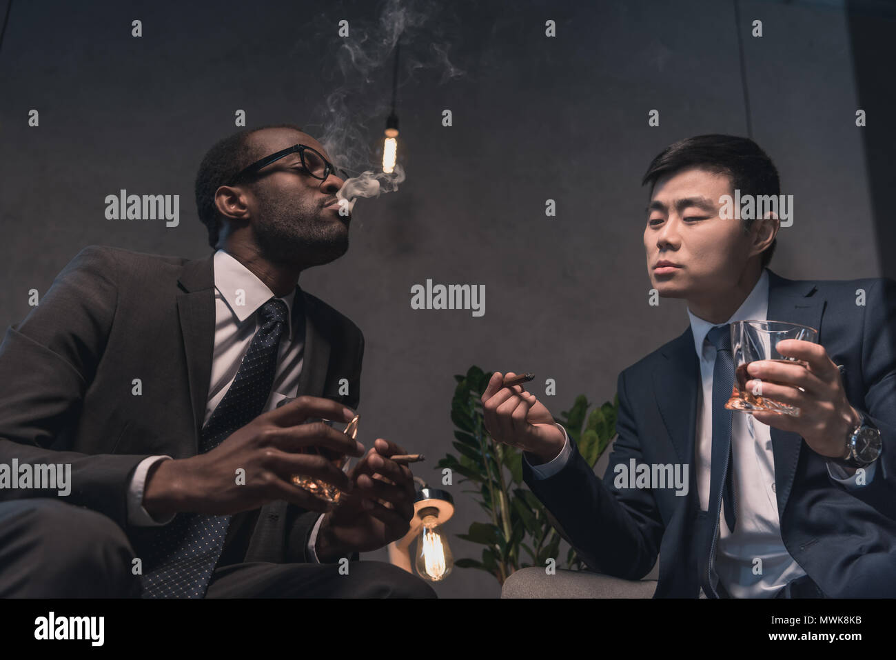 Hommes d'multiethic avec succès détente sur fauteuil Banque D'Images