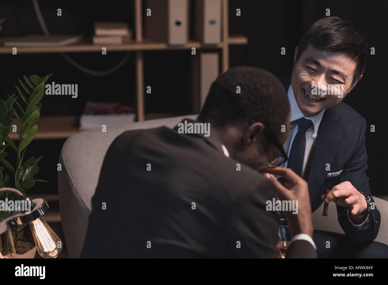 Hommes d'multiethic avec succès rire in dark room Banque D'Images
