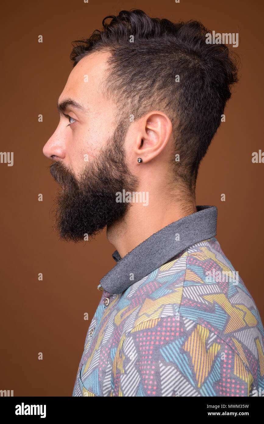 Beau jeune homme persan barbus contre fond brun Banque D'Images