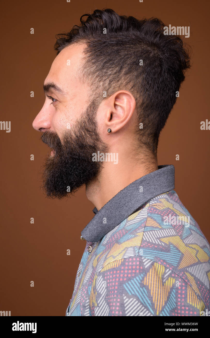 Beau jeune homme persan barbus contre fond brun Banque D'Images
