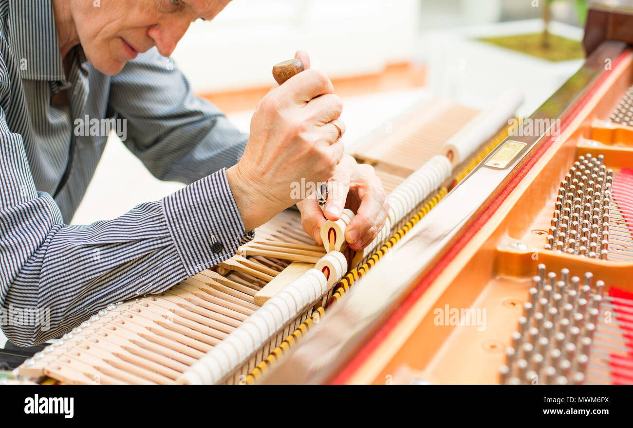 Personnes âgées technicien piano mécanisme de réparation. Banque D'Images