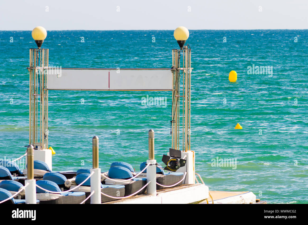 Transats sur la jetée avec l'eau bleue turquoise à l'avant Banque D'Images