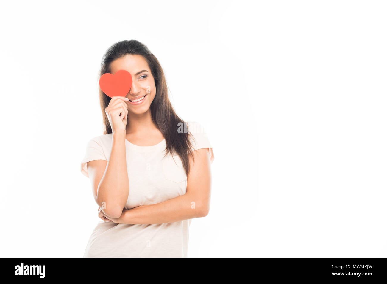 'Portrait of attractive young woman with red paper heart sur l'oeil, isolated on white Banque D'Images