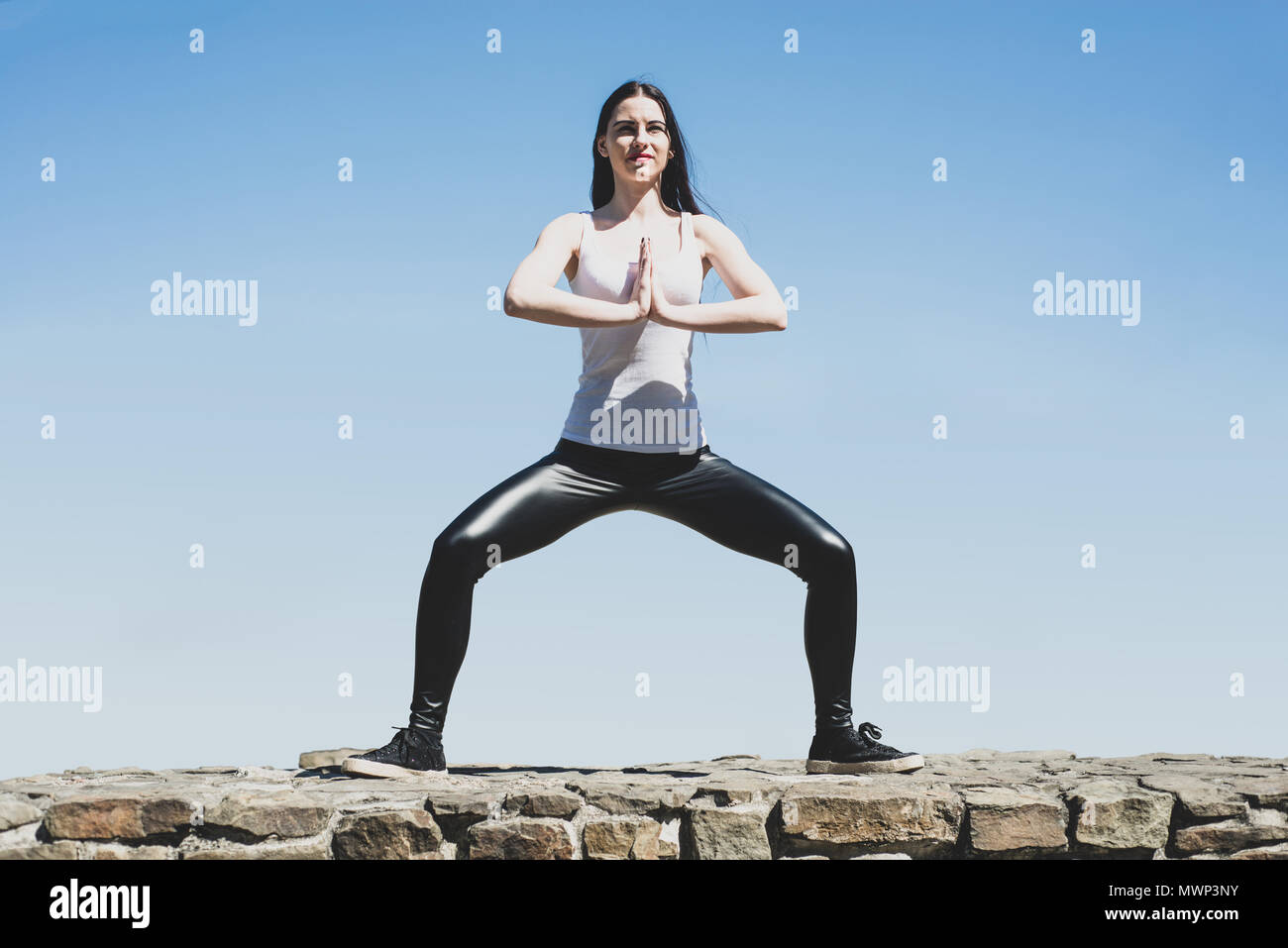 Une vue d'une femme dans une pose de yoga haute au-dessus de la terre. La femme exerce et prend soin de sa figure et l'état. Jolie et athletic girl se réchauffe Banque D'Images