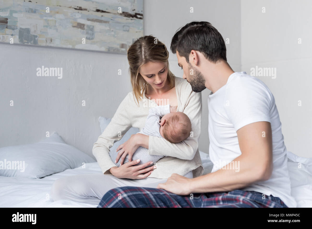 Les jeunes époux à la mère comment nourrir petit bébé Banque D'Images