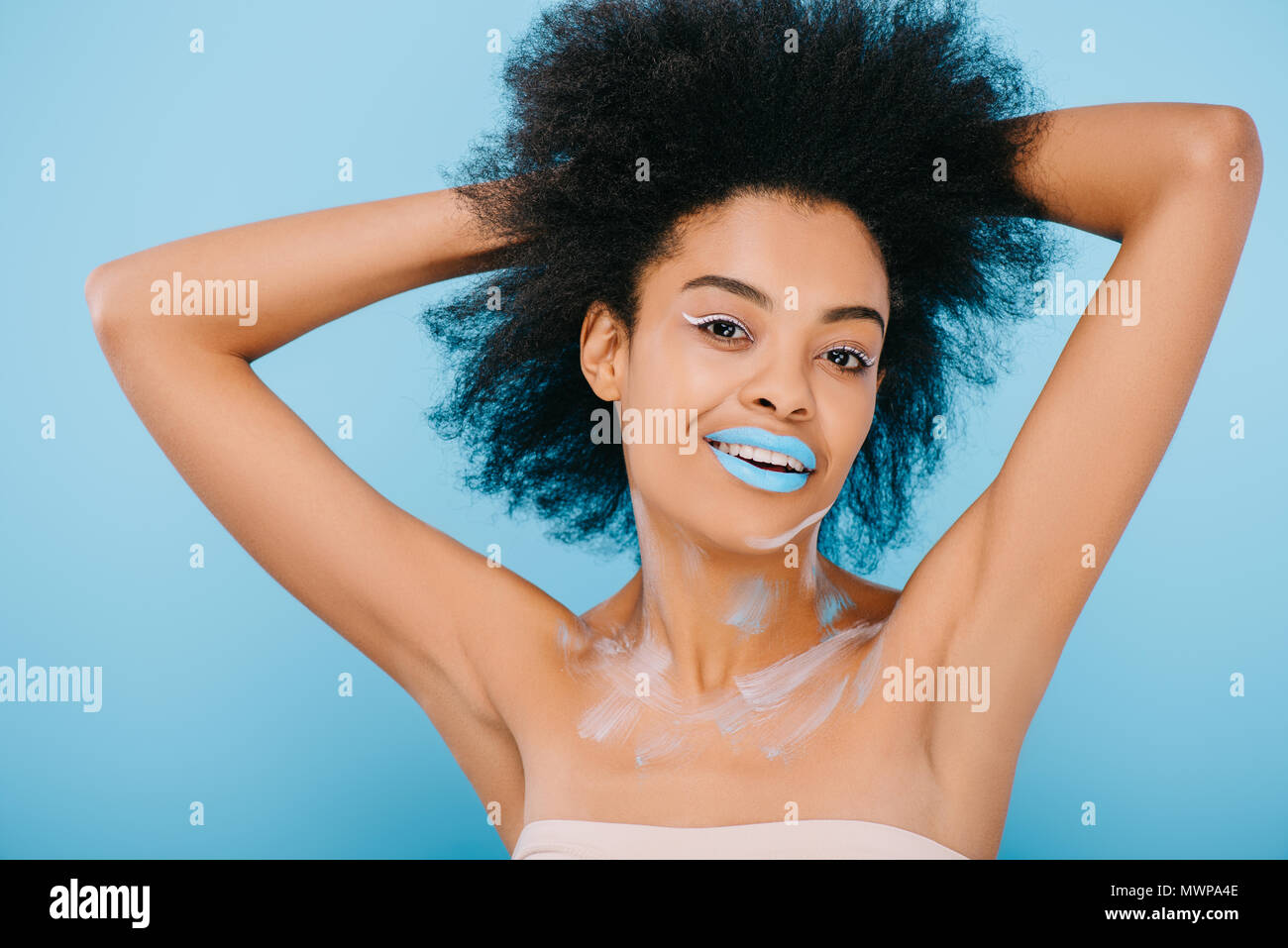 Happy young woman with creative et maquillage lèvres bleu sur bleu isolé Banque D'Images