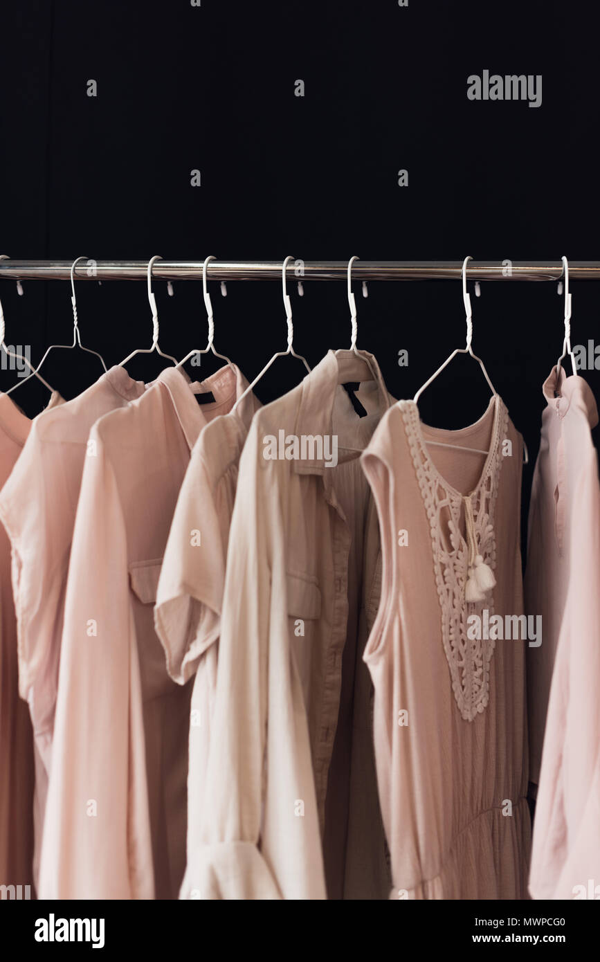 Vue rapprochée de l'habillement féminin organisé sur la pendaison porte  manteau isolé sur black Photo Stock - Alamy