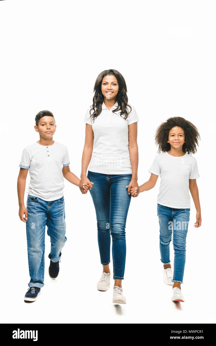 Beautiful happy african american mother avec mignon enfants tenant la main tout en marchant ensemble isolated on white Banque D'Images